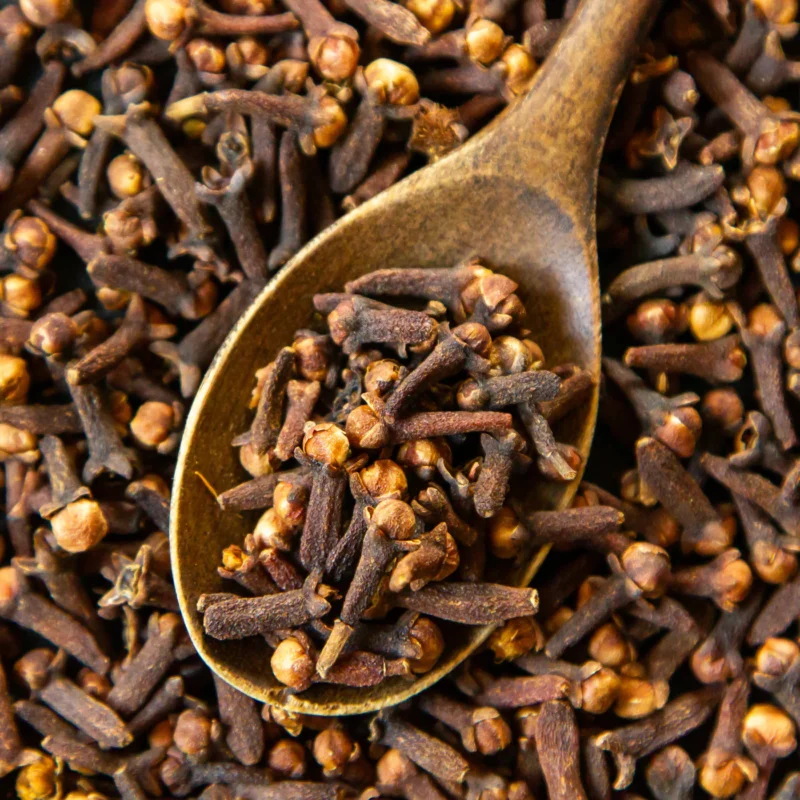 top view dried cloves with wooden spoon 1400x
